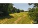 Wide shot of large lot showing partially cut grass and trees in the distance at 1040 Nc 90 W Hwy, Taylorsville, NC 20681