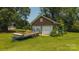 Brick outbuilding with roll-up doors and adjacent yard, presenting opportunities for workshops or storage at 1040 Nc 90 W Hwy, Taylorsville, NC 20681