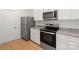 Modern kitchen with stainless steel appliances, granite countertops, and white cabinets, next to a door at 1055 Doran Ter, Richburg, SC 29729