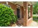 Close-up of a brick front porch and black front door with a well-maintained shrub at 1141 Ardwyck Pl, Rock Hill, SC 29730