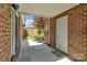 Covered patio with red brick walls, white door, and access to private garden at 1141 Ardwyck Pl, Rock Hill, SC 29730