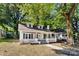 Charming one-story home with dormer windows and a welcoming front porch surrounded by mature trees and ample space at 115 W 5Th Ave, Gastonia, NC 28052