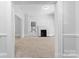 Spacious living room featuring neutral walls, carpet flooring, and a cozy brick fireplace at 115 W 5Th Ave, Gastonia, NC 28052