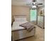 Cozy bedroom featuring a stylish wooden bed frame and neutral decor, illuminated by a ceiling fan and natural light at 136 Elba Dr, Mooresville, NC 28115