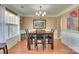 Elegant dining room featuring hardwood floors, wainscoting, large window, and stylish chandelier at 136 Elba Dr, Mooresville, NC 28115