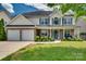 Beautiful two-story home with a stone facade, covered porch, and lush landscaping in a Gathering-friendly neighborhood at 136 Elba Dr, Mooresville, NC 28115