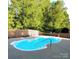 Enjoy a refreshing dip in this kidney-shaped pool, surrounded by a wooden fence and lush greenery at 136 Elba Dr, Mooresville, NC 28115