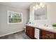 Bathroom with double sink vanity, gray walls, wood-look flooring, and natural light at 137 S Penny St, Lancaster, SC 29720