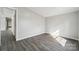Neutral-toned bedroom featuring gray laminate floors and a doorway to another room at 137 S Penny St, Lancaster, SC 29720