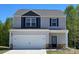 Two story home featuring a two-car garage, gray siding, and a manicured lawn at 1542 Doran Ter, Richburg, SC 29729
