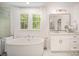A luxurious bathroom features soaking tub, sleek fixtures, and picturesque views from the window at 16432 Here At Last Ln, Charlotte, NC 28278