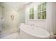 A luxurious bathroom features soaking tub, sleek fixtures, and glass enclosed shower at 16432 Here At Last Ln, Charlotte, NC 28278
