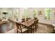 Hardwood floors, natural light, neutral rug and wood table with seating for six define this dining space at 16432 Here At Last Ln, Charlotte, NC 28278