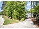 Long driveway leading to a modern farmhouse, surrounded by lush green trees at 16432 Here At Last Ln, Charlotte, NC 28278