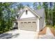 Side view of a modern white farmhouse with a two-car garage and a stone path alongside the driveway at 16432 Here At Last Ln, Charlotte, NC 28278