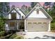 Beautiful two-story farmhouse with white siding, black trim, and a welcoming front porch and attached garage at 16432 Here At Last Ln, Charlotte, NC 28278