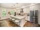 Spacious kitchen featuring stainless steel appliances, a large island with seating, and hardwood flooring at 16432 Here At Last Ln, Charlotte, NC 28278