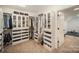 A large walk-in closet features custom shelves, drawers, hanging storage and carpet floors at 16432 Here At Last Ln, Charlotte, NC 28278