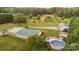 Aerial view showcasing the home, detached garage, and backyard above-ground pool with decking, set amidst mature trees at 1720 Lowe Dr, Catawba, NC 28609