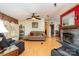 Cozy living room featuring a stone fireplace, ceiling fan, wood-look flooring, and comfortable seating at 1720 Lowe Dr, Catawba, NC 28609