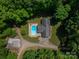 Aerial view of the home with a pool, detached garage, and driveway surrounded by mature trees at 174 Buena Vale Dr, Gastonia, NC 28056
