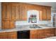 Bright kitchen featuring wood cabinets, granite countertops, stainless steel sink, and natural light from a window at 174 Buena Vale Dr, Gastonia, NC 28056