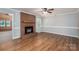 Cozy living room with hardwood floors, a brick fireplace, and neutral wall colors creating a warm atmosphere at 174 Buena Vale Dr, Gastonia, NC 28056
