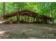 View of an outbuilding in a wooded area, showing its wooden structure and storage space at 174 Buena Vale Dr, Gastonia, NC 28056