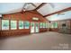 Spacious sun room with wood paneled walls, fireplace, and access to outdoor pool at 174 Buena Vale Dr, Gastonia, NC 28056