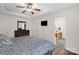 A well-lit bedroom featuring a ceiling fan, wooden dresser, and doorway into the en-suite bathroom at 208 N Kayla Dr, Salisbury, NC 28146