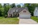 Charming single Gathering home featuring a two-car garage, manicured lawn, and decorative dormers, and mature trees at 208 N Kayla Dr, Salisbury, NC 28146