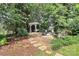 Landscaped backyard with a pergola swing, stepping stones, and mature trees at 2289 Veery Ln, Rock Hill, SC 29732