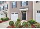 Detailed exterior shot of a townhouse, highlighting the front door, garage, and tidy landscaping at 2635 Mccurdy Trl, Charlotte, NC 28269