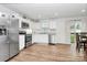 Open kitchen area with stainless steel appliances, white cabinets, and dining area at 2635 Mccurdy Trl, Charlotte, NC 28269