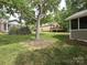Lush backyard with mature trees, a deck, a patio, and multiple structures at 2919 Peachwood Ct, Fort Mill, SC 29715
