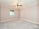Bright bedroom with ceiling fan, neutral carpet, and a window providing natural light at 2919 Peachwood Ct, Fort Mill, SC 29715