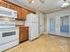 Kitchen features white appliances, wooden cabinets, and access to an outdoor area at 2919 Peachwood Ct, Fort Mill, SC 29715