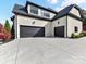 Three-car garage with black doors, a spacious driveway, and beautiful landscaping, offering ample parking and curb appeal at 2954 Holbrook Rd, Fort Mill, SC 29715