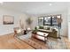 Cozy living room with hardwood floors, a green sofa, and a large window at 2954 Holbrook Rd, Fort Mill, SC 29715