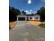 Charming white home with an attached garage and a long driveway nestled amongst mature trees at 3137 Riber Ln, Claremont, NC 28610