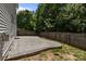 Relaxing backyard patio with a stone paver design, enhanced by a lush green backdrop of mature trees at 4729 Nijinsky Ct, Charlotte, NC 28216