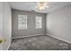 Neutral bedroom featuring two windows and soft gray carpet at 4729 Nijinsky Ct, Charlotte, NC 28216