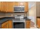 Kitchen featuring stainless steel oven with wooden cabinets and black countertops at 4729 Nijinsky Ct, Charlotte, NC 28216