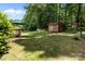 Expansive backyard showcases a shed with double doors, an umbrella, and ample space for outdoor activities and relaxation at 503 Overbrook Dr, Albemarle, NC 28001