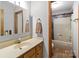 Bathroom vanity with sink and mirror next to an open door revealing the shower and tub at 503 Overbrook Dr, Albemarle, NC 28001