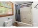 Bathroom featuring a toilet and a bathtub with shower head next to a window at 503 Overbrook Dr, Albemarle, NC 28001