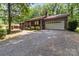 A well-maintained home with a garage and a cozy front porch nestled in a green landscape at 503 Overbrook Dr, Albemarle, NC 28001