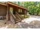 Inviting front entrance featuring stone steps, covered porch with wood accents, and a lush green lawn, complete with landscaping at 503 Overbrook Dr, Albemarle, NC 28001