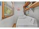 Bright laundry room with washer, dryer, and window for natural light; shelving for storage at 503 Overbrook Dr, Albemarle, NC 28001