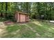 Backyard shed with double doors, features a stone paver path, nestled in a serene, wooded area at 503 Overbrook Dr, Albemarle, NC 28001